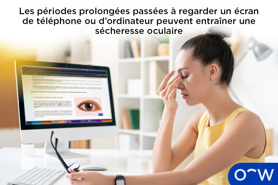 Une femme regardant un ordinateur et ressentant des symptômes de sécheresse oculaire