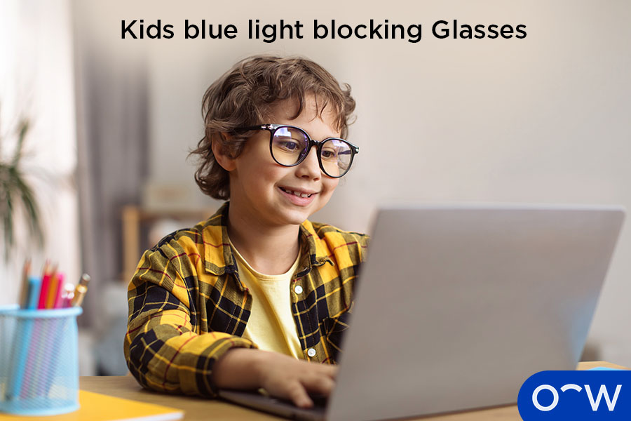 A child wearing blue light-blocking glasses while using a laptop.