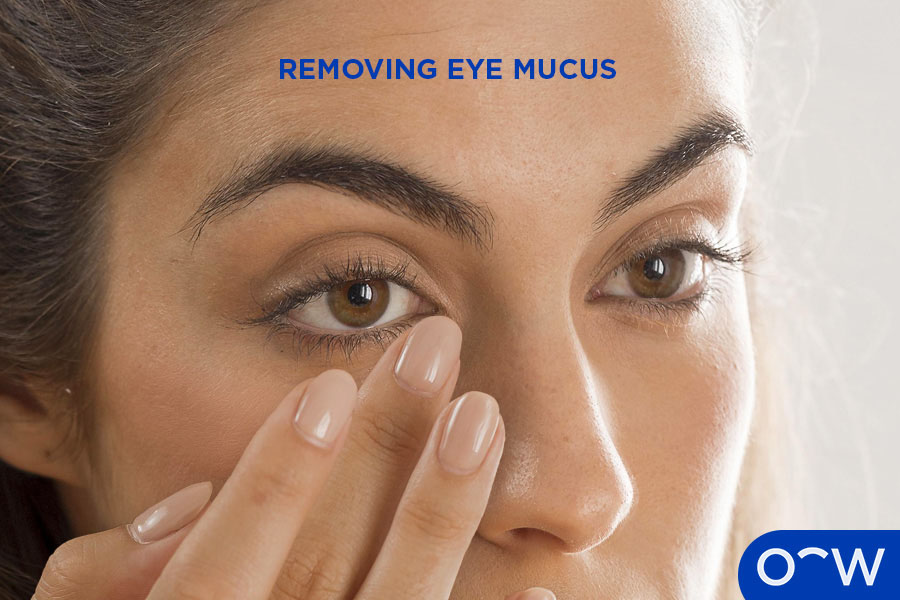 A woman removing eye mucus with her fingers.