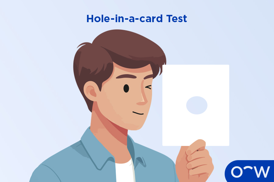 A person doing a hole-in-a-card test, to determine which eye is dominant.