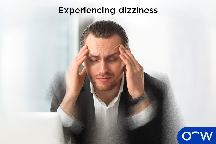 The image shows a man experiencing dizziness.