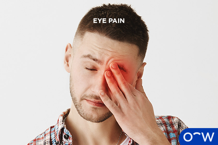Man holding his finger over his painful eye, pain is indicated by a red spot over the affected eye.