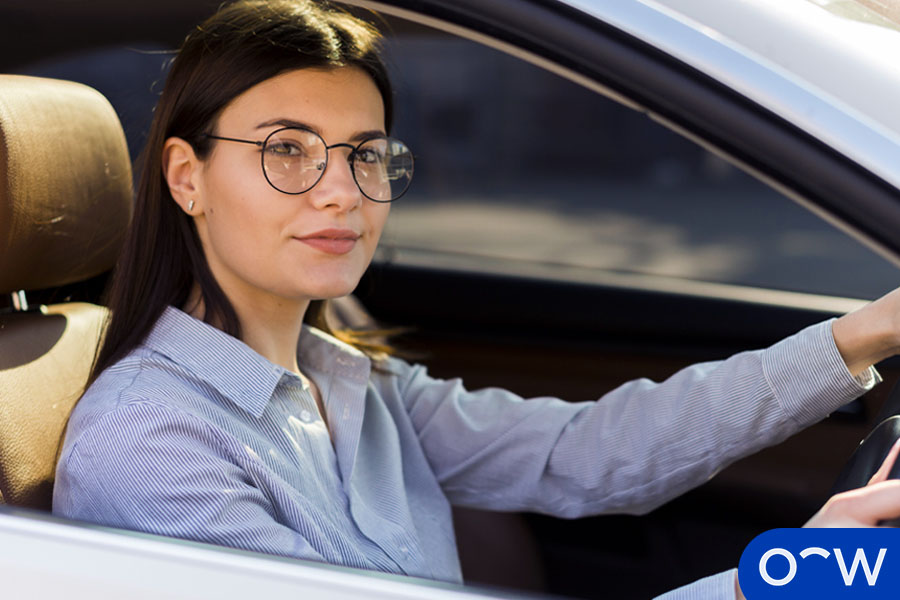 A woman with glasses driving