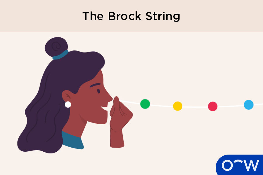 A person with a brock string held up to their nose as an eye exercise for strabismus.