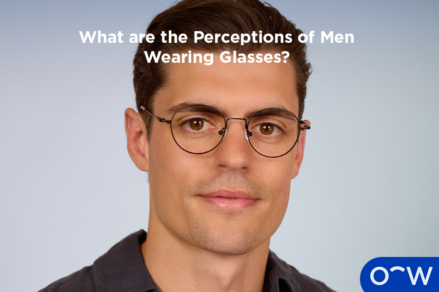 A man wearing round, thin glasses staring at the camera.